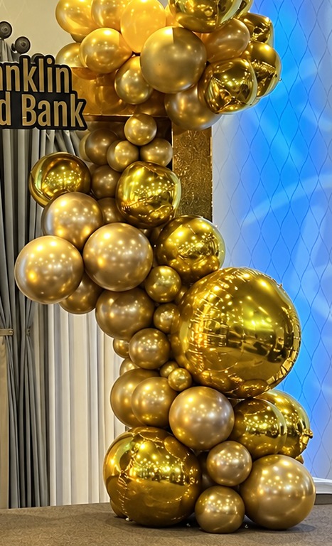 Detail of glossy gold and champagne balloons in varying sizes